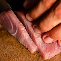 Precision slicing of premium tuna for sashimi at Billy Ho chef hand slicing fresh tuna sashimi at Billy Ho modern Japanese restaurant in Canggu