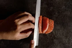 Fresh salmon sashimi, expertly sliced at our modern Japanese kitchen in Canggu hand slicing fresh salmon sashimi at Billy Ho modern Japanese restaurant in Canggu